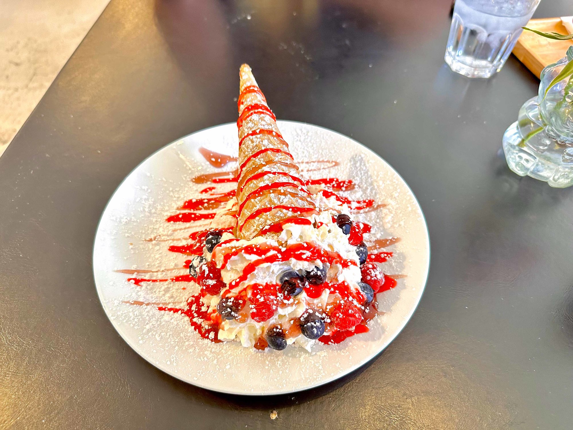 dessert cone with ice cream and whipped cream topped with fruit